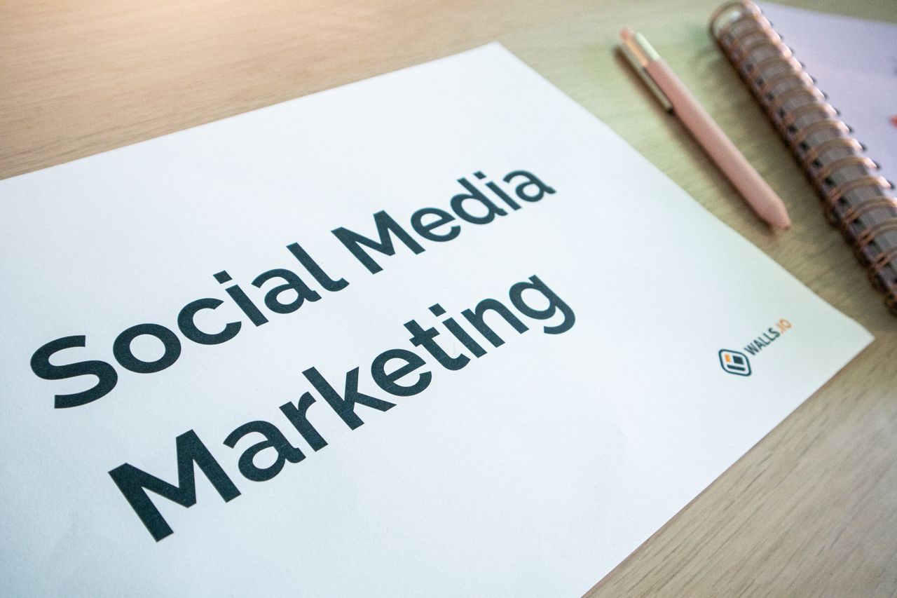 services-06 Close-up of a social media marketing document on a desk with a pen and notebook.