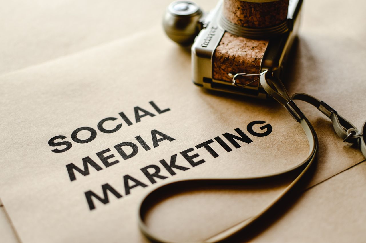 about-01 Close-up of a camera placed on brown paper with Social Media Marketing text, highlighting digital marketing themes.